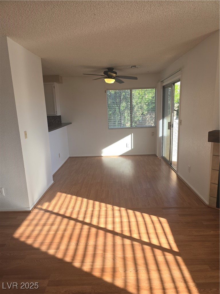 2232 Aspen Mirror Way, Unit 204 Laughlin, NV 89029 - Photo 15 of 37 Unfurnished living room with wood finished floors, a ceiling fan, a textured ceiling, and baseboards