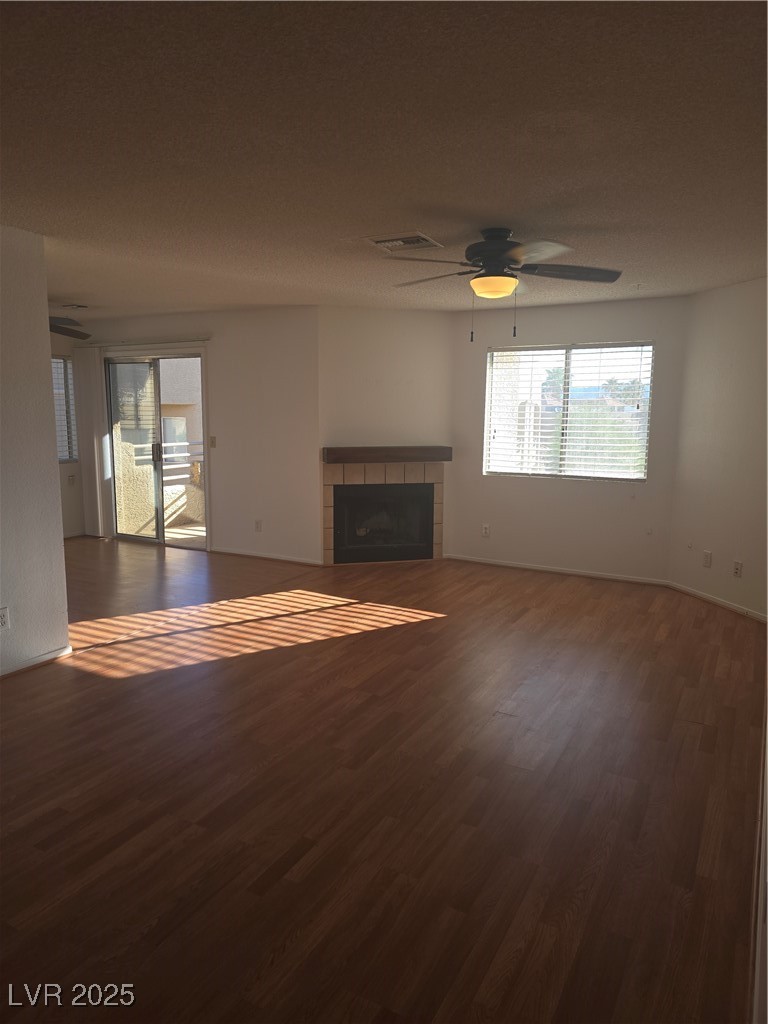 2232 Aspen Mirror Way, Unit 204 Laughlin, NV 89029 - Photo 2 of 37 Unfurnished living room with wood finished floors, a tiled fireplace, and ceiling fan