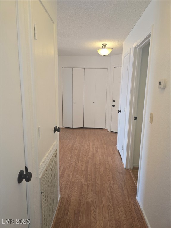2232 Aspen Mirror Way, Unit 204 Laughlin, NV 89029 - Photo 24 of 37 Corridor with wood finished floors, a textured ceiling, and baseboards