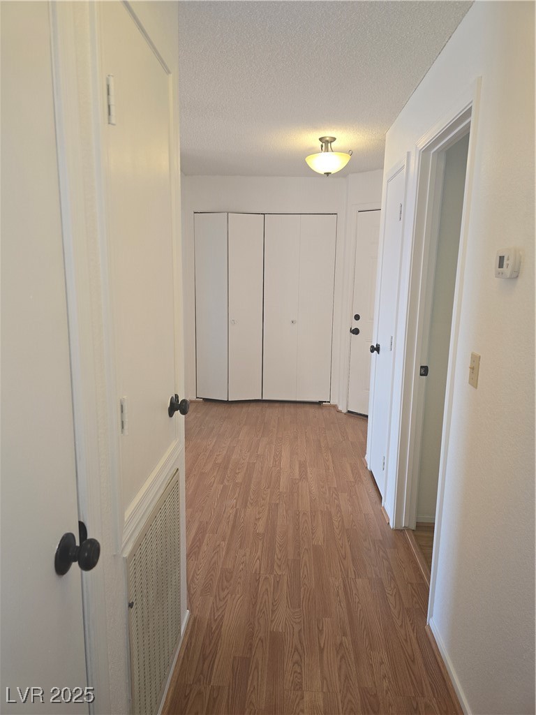 2232 Aspen Mirror Way, Unit 204 Laughlin, NV 89029 - Photo 24 of 37 Corridor with wood finished floors, a textured ceiling, and baseboards