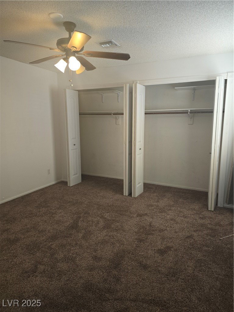 2232 Aspen Mirror Way, Unit 204 Laughlin, NV 89029 - Photo 26 of 37 Unfurnished bedroom featuring multiple closets, carpet flooring, a textured ceiling, and ceiling fan