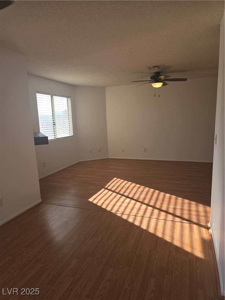 2232 Aspen Mirror Way, Unit 204 Laughlin, NV 89029 - Photo 5 of 37 Empty room featuring wood finished floors, ceiling fan, a textured ceiling, and baseboards