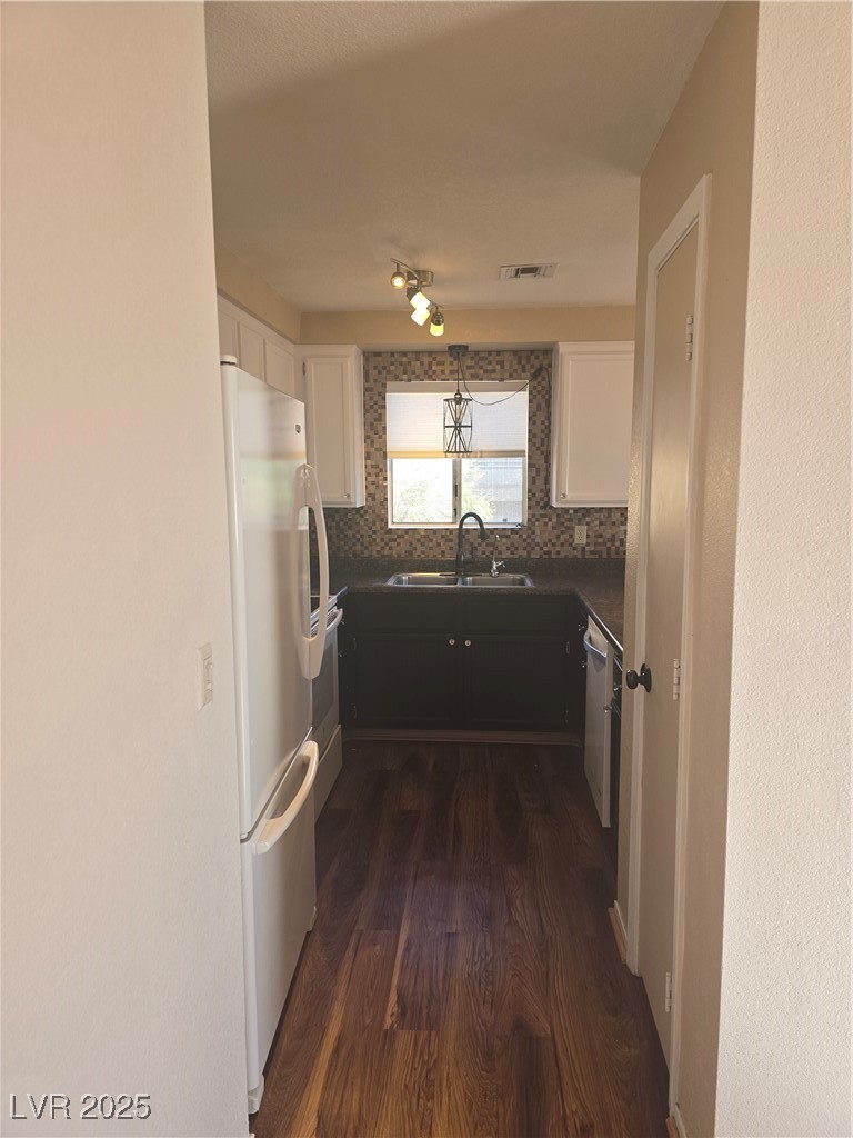 2232 Aspen Mirror Way, Unit 204 Laughlin, NV 89029 - Photo 10 of 37 Kitchen featuring a sink, refrigerator, dark countertops, dark wood-style floors, and tasteful backsplash
