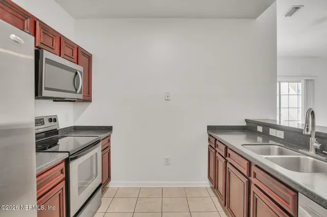 a kitchen with granite countertop a sink stove top oven and microwave