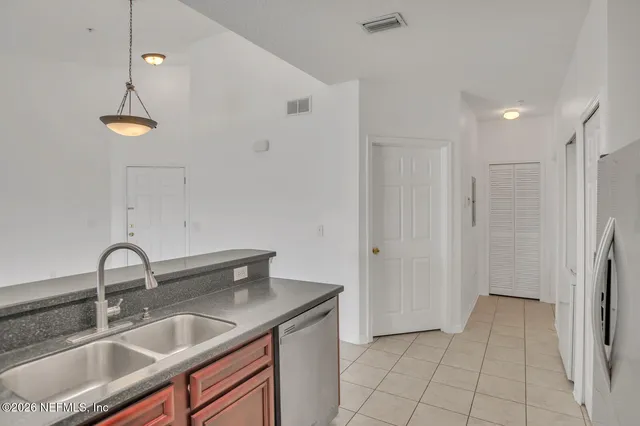 a kitchen with stainless steel appliances granite countertop a sink a refrigerator and a sink