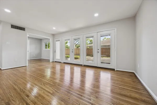 a view of empty room with wooden floor and fireplace