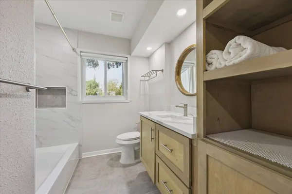 a bathroom with a granite countertop sink a toilet and a bathtub