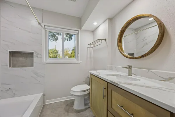 a bathroom with a toilet a sink and mirror