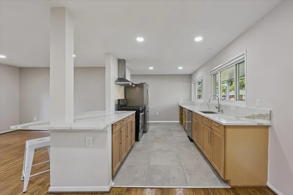a kitchen with kitchen island granite countertop a sink and refrigerator