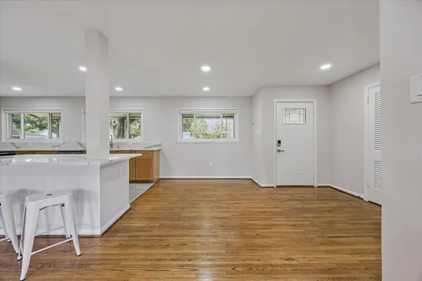 a view of empty room with wooden floor and windows