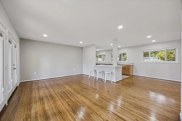 a living room with kitchen furniture and a wooden floor