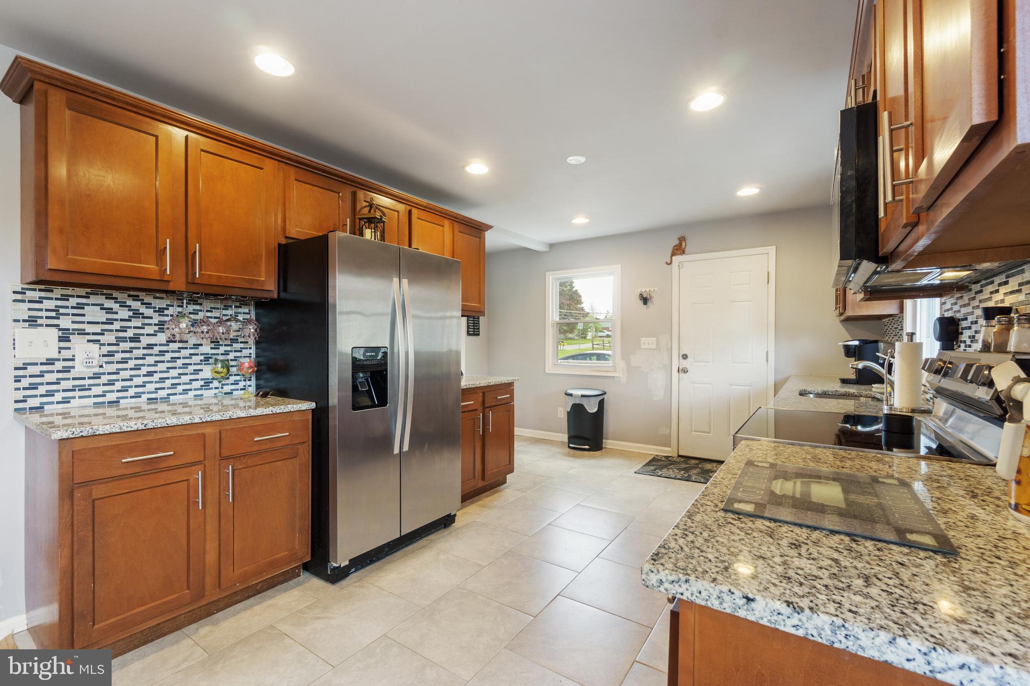 1556 Fairmount Road Hampstead, MD 21074 - Photo 5 of 48 a kitchen with stainless steel appliances granite countertop a refrigerator a stove and a sink with wooden cabinets
