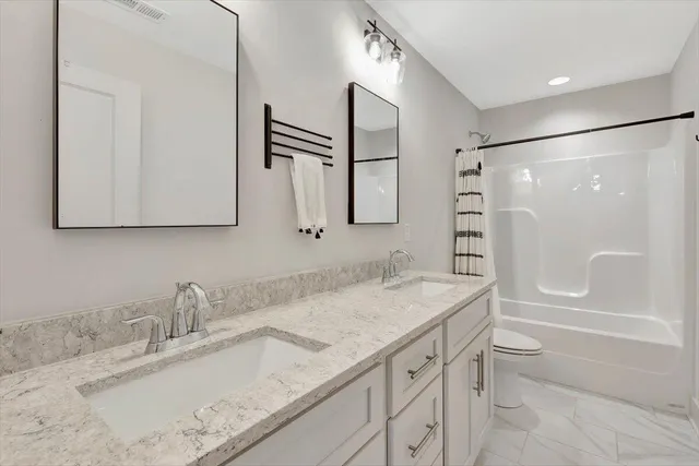 a bathroom with a granite countertop sink toilet and shower