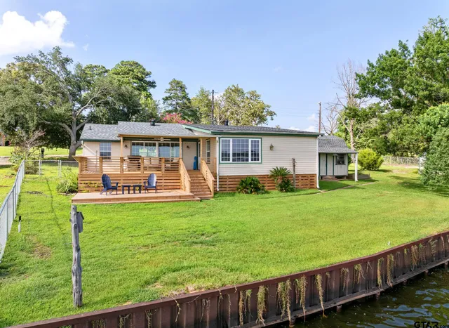 an aerial view of a house with a garden and lake view