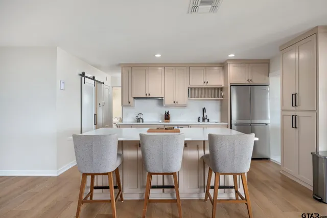 a kitchen with a dining table chairs and refrigerator