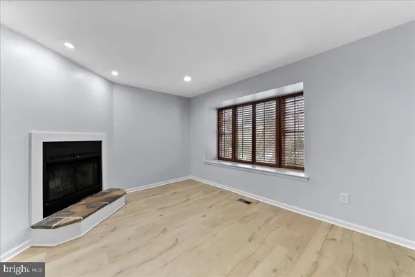 a view of an empty room with a fireplace and a window