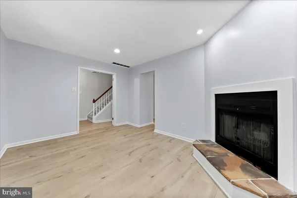 a view of empty room with wooden floor and fireplace