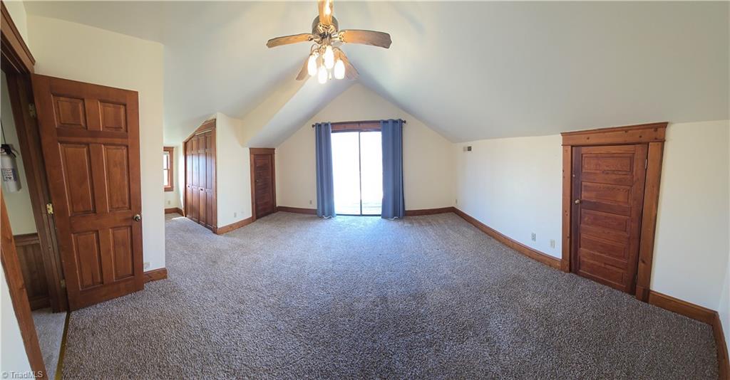 1077 Flat Shoals Road King, NC 27021 - Photo 33 of 46 Large bedroom opens onto a deck. The alcove features closets and eave storage is available through the door on the right. Vaulted ceiling adds to the spacious feel.