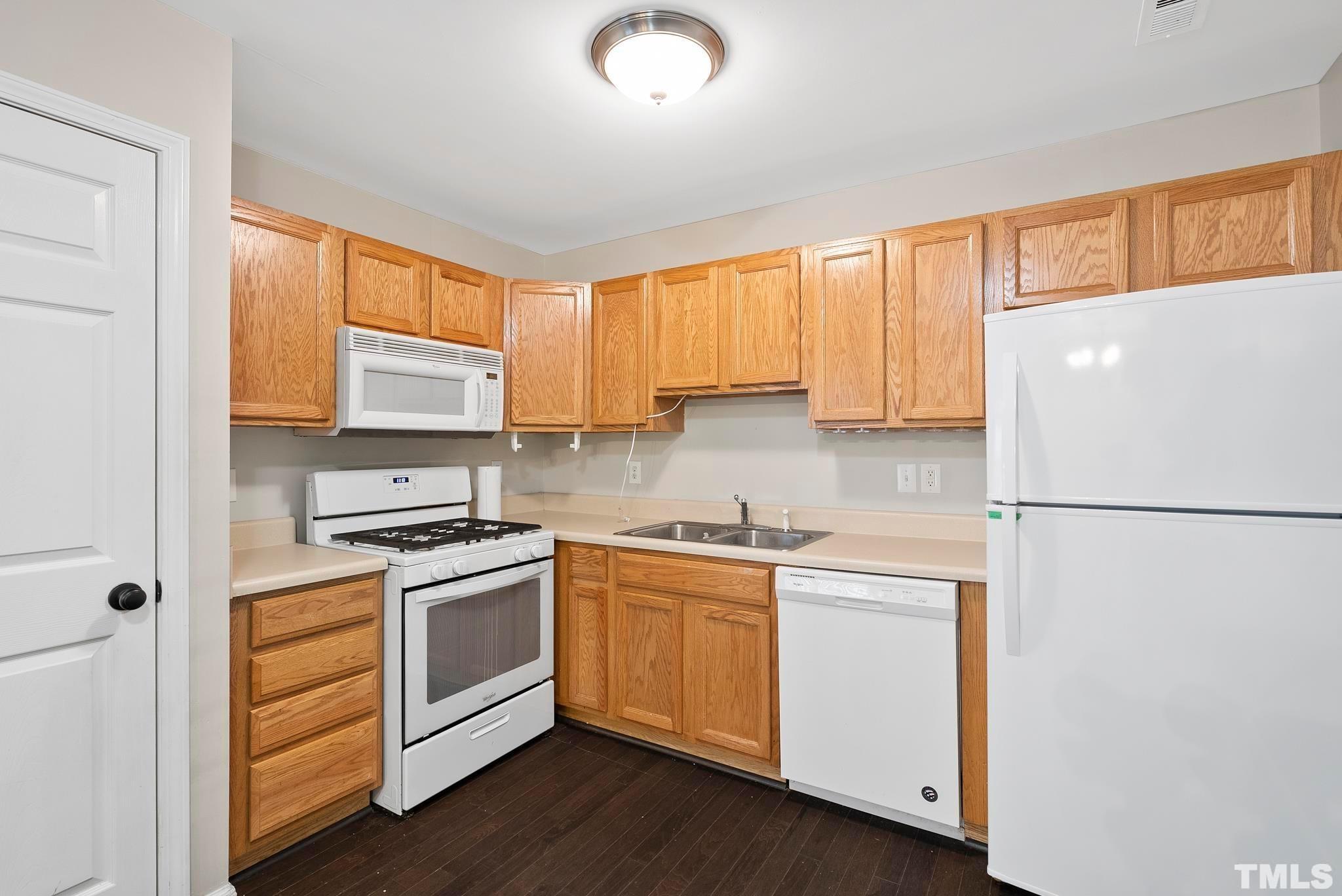 3011 Barrymore Street, Unit 107 Raleigh, NC 27603 - Photo 12 of 33 a kitchen with white cabinets and white appliances