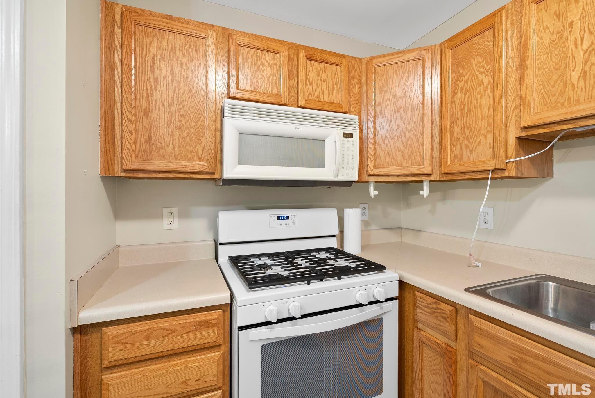 3011 Barrymore Street, Unit 107 Raleigh, NC 27603 - Photo 13 of 33 a kitchen with granite countertop cabinets stainless steel appliances and a sink