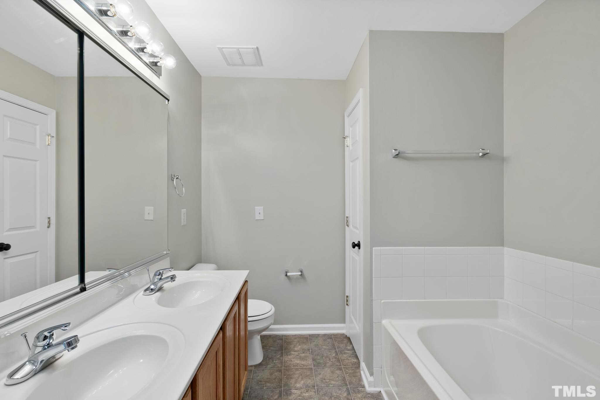 3011 Barrymore Street, Unit 107 Raleigh, NC 27603 - Photo 22 of 33 a bathroom with a sink a toilet and shower