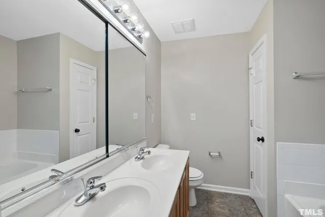 a bathroom with a granite countertop sink toilet a shower and a mirror
