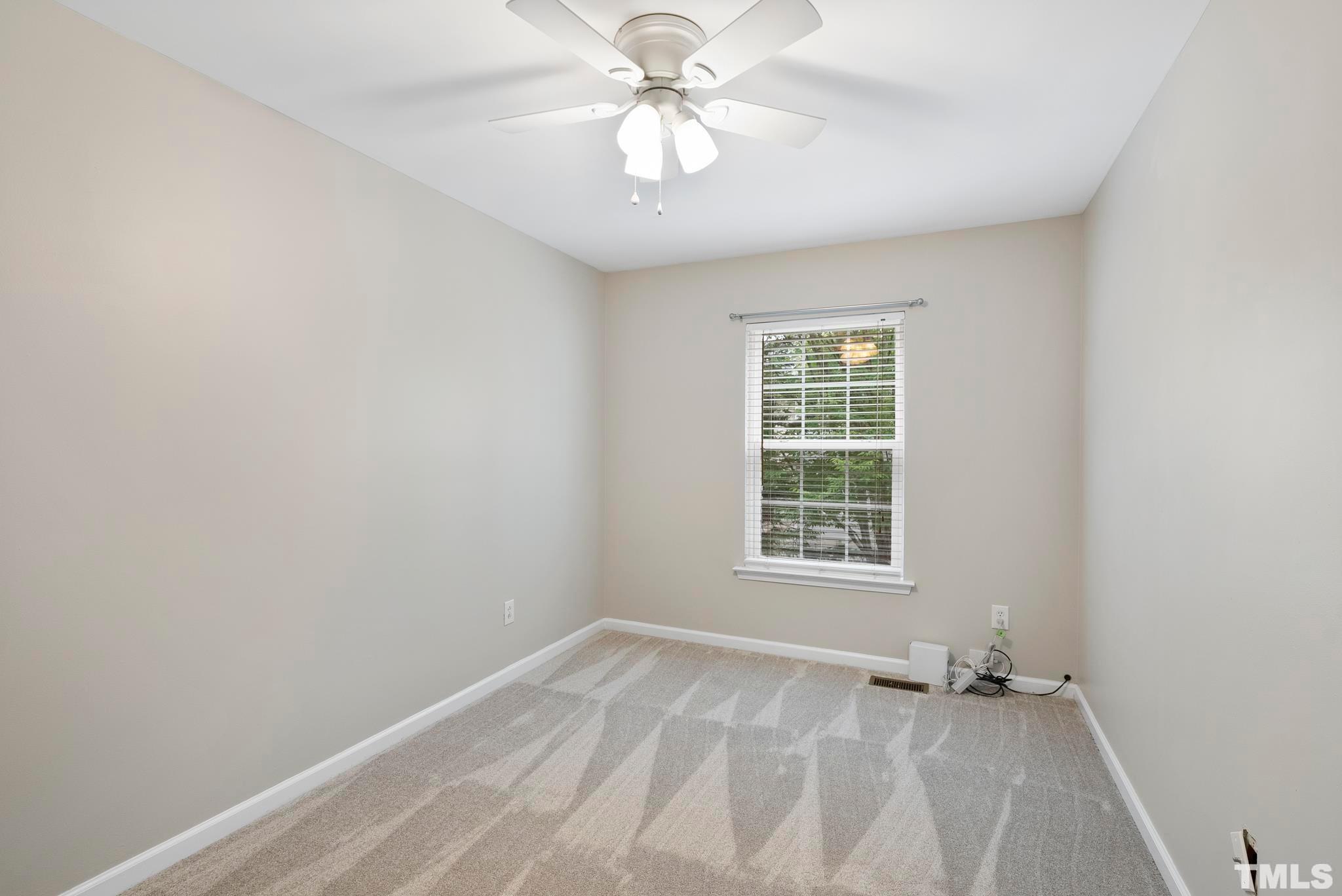 3011 Barrymore Street, Unit 107 Raleigh, NC 27603 - Photo 26 of 33 an empty room with a window and a fan