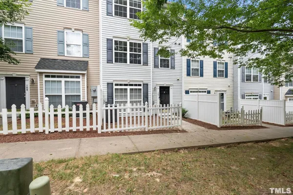 a view of a house with a small yard and wooden fence