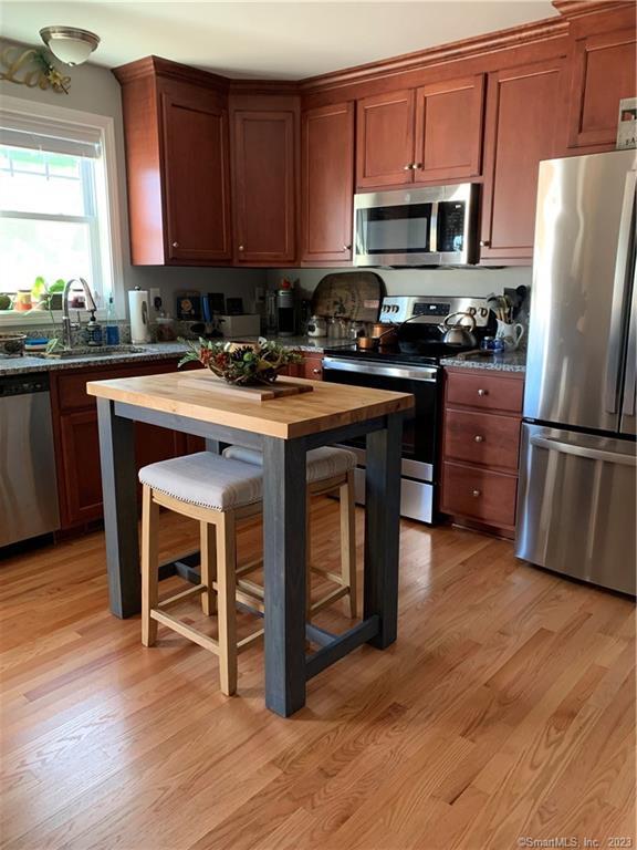 Four Twenty Four Bumper Road Harwinton, CT 06791 - Photo 25 of 28 a kitchen with wooden floors and wooden cabinets