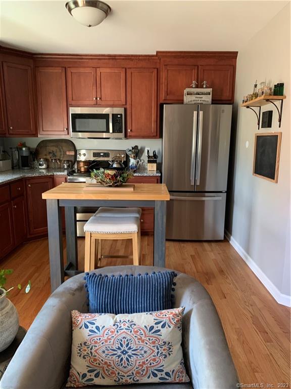 Four Twenty Four Bumper Road Harwinton, CT 06791 - Photo 26 of 28 a kitchen with stainless steel appliances granite countertop a refrigerator a stove a sink and a microwave with wooden floor