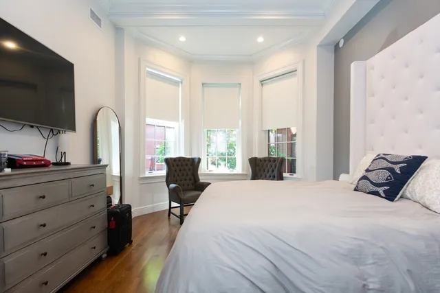 a bedroom with a bed and large windows