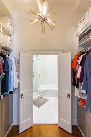 a view of walk in closet with clothes and shoes