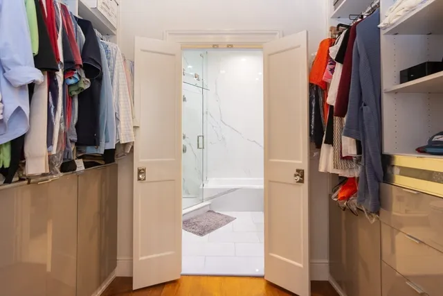 a view of walk in closet with clothes and shoes