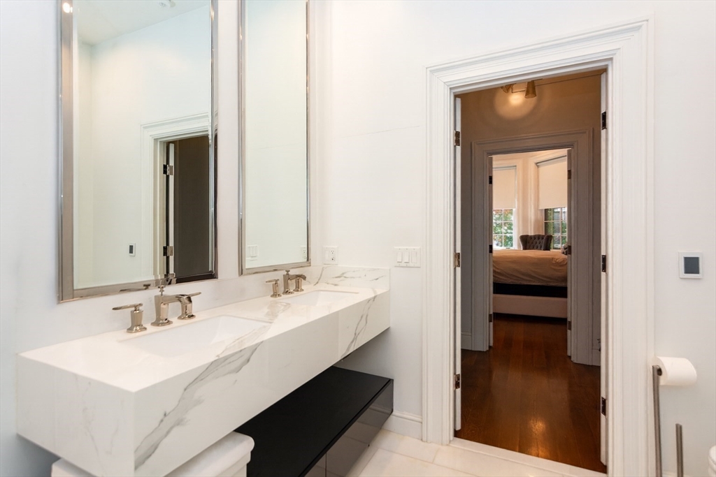 288 Commonwealth Avenue, Unit 1 Boston, MA 02115 - Photo 17 of 36 a en suite bathroom with a sink a mirror and vanity