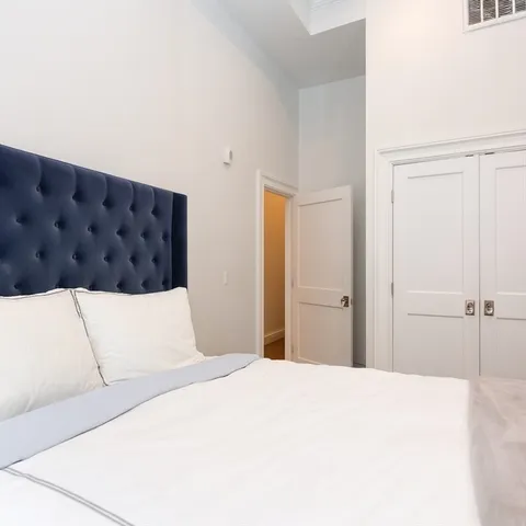 a bedroom with a large bed and a chandelier