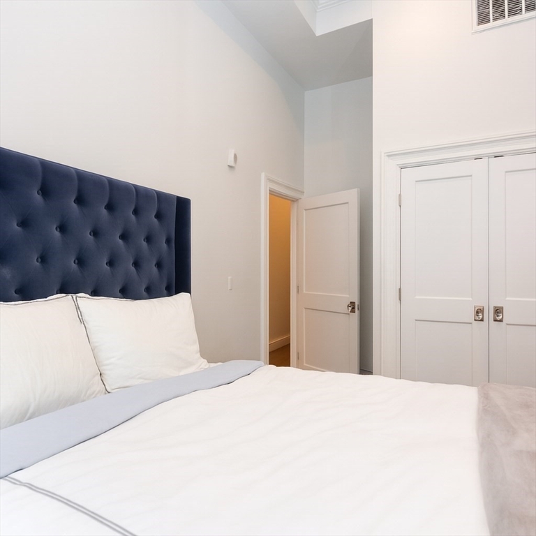 288 Commonwealth Avenue, Unit 1 Boston, MA 02115 - Photo 23 of 36 a bedroom with a large bed and a chandelier