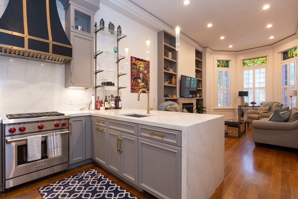 288 Commonwealth Avenue, Unit 1 Boston, MA 02115 - Photo 4 of 36 a kitchen with stainless steel appliances granite countertop a stove and a sink