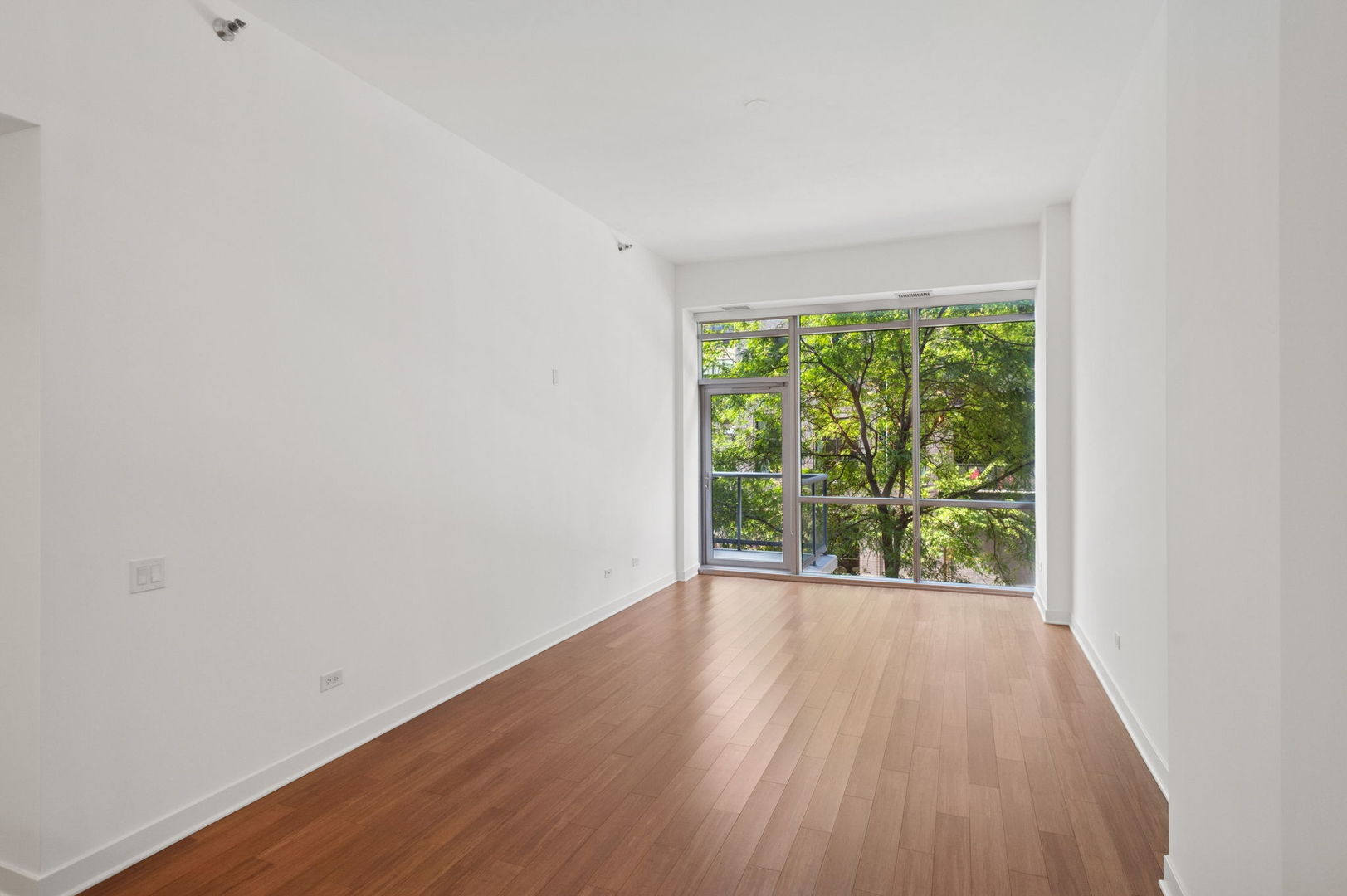 125 South Green Street, Unit 209A Chicago, IL 60607 - Photo 3 of 16 a view of an empty room with wooden floor and a window