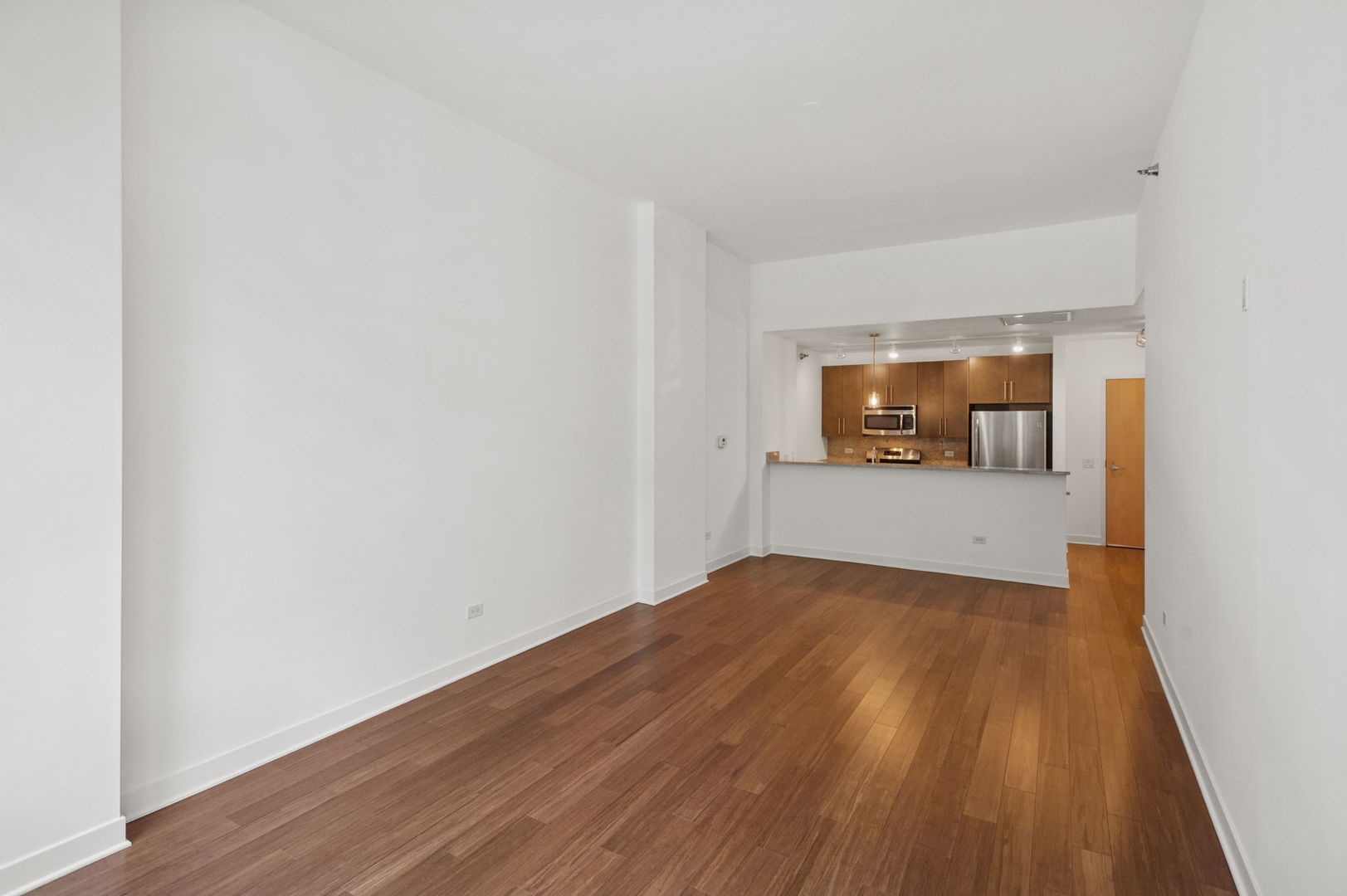 125 South Green Street, Unit 209A Chicago, IL 60607 - Photo 5 of 16 a view of a room that has wooden floor and a window