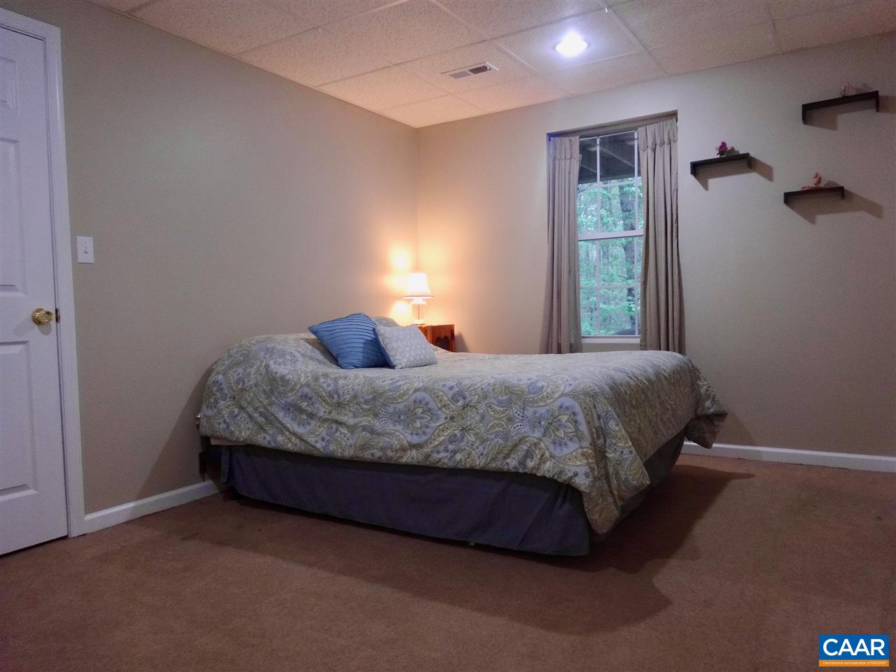 654 Miller School Road Charlottesville, VA 22903 - Photo 15 of 22 a bedroom with a bed lamp and a window