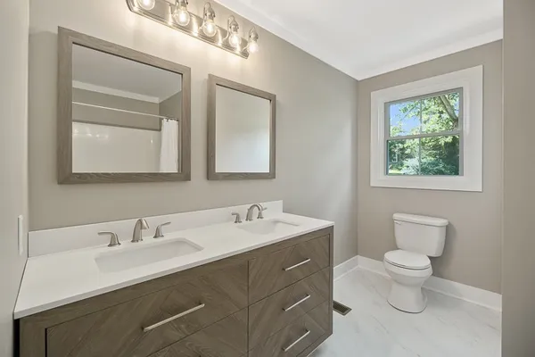 a bathroom with a sink a toilet and shower