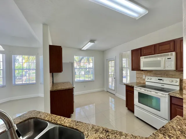 a kitchen with stainless steel appliances kitchen island granite countertop a stove and a sink