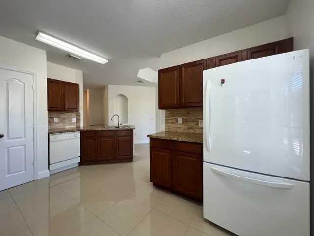 a kitchen with a refrigerator and a sink