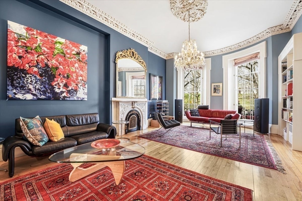 a living room with furniture chandelier and a rug