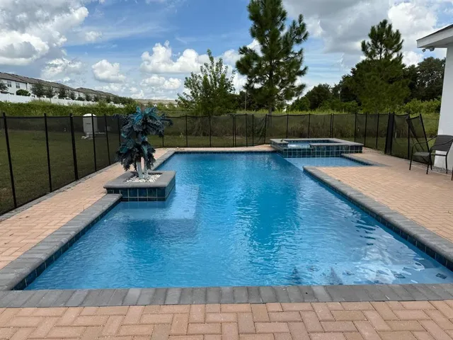 a view of a swimming pool with a patio and a garden