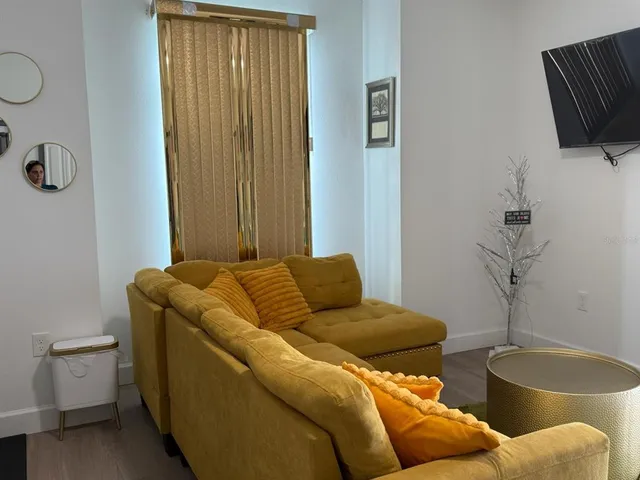 a living room with furniture and a wooden floor