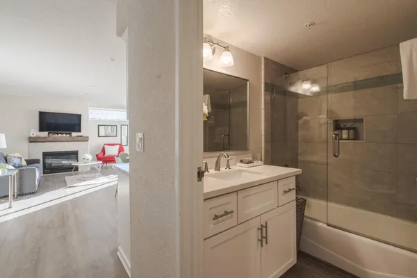 a bathroom with a sink a large mirror and a shower