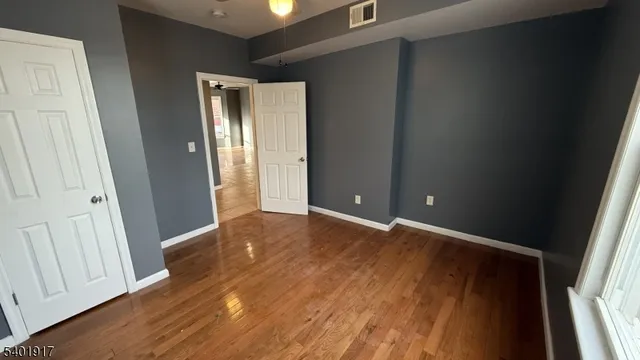 an empty room with wooden floor and closet