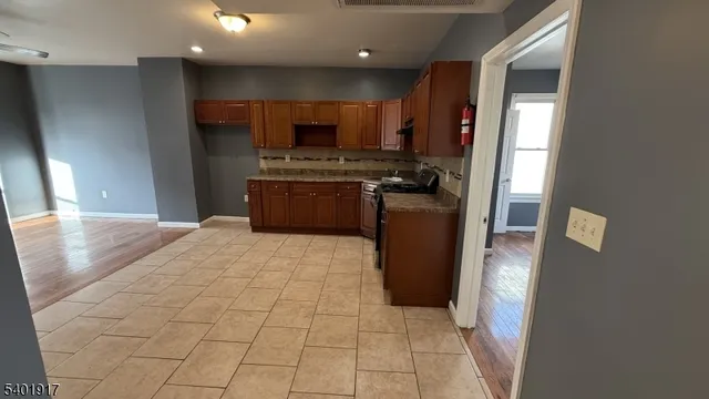 a kitchen with stainless steel appliances granite countertop a refrigerator and a stove