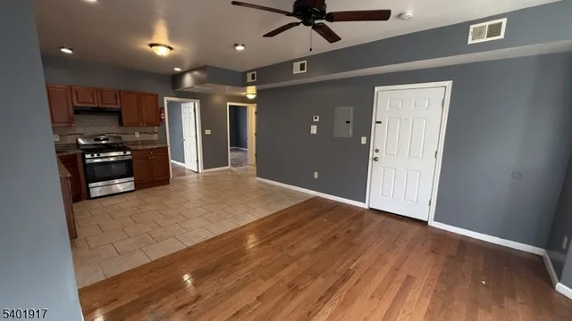 a kitchen with stainless steel appliances granite countertop a refrigerator oven a stove top oven with wooden floor